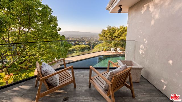 a bathroom with double vanity sinks a large mirror and a bathtub