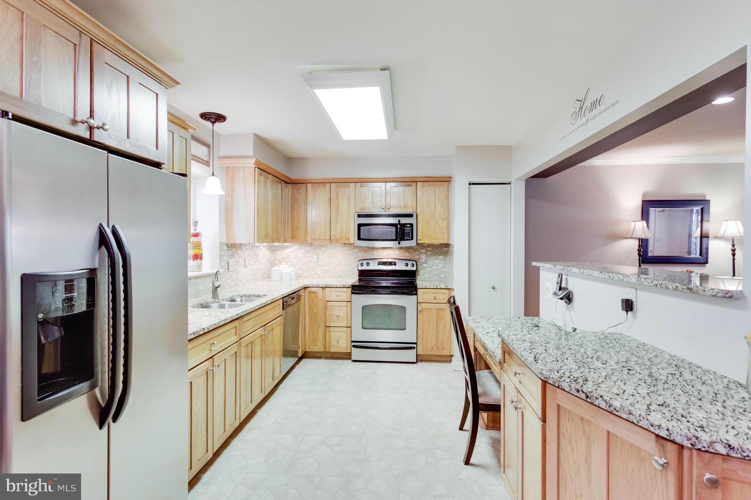 1547 Inlet Court Reston, VA 20190 - Photo 10 of 30 a kitchen with stainless steel appliances granite countertop a sink refrigerator and microwave