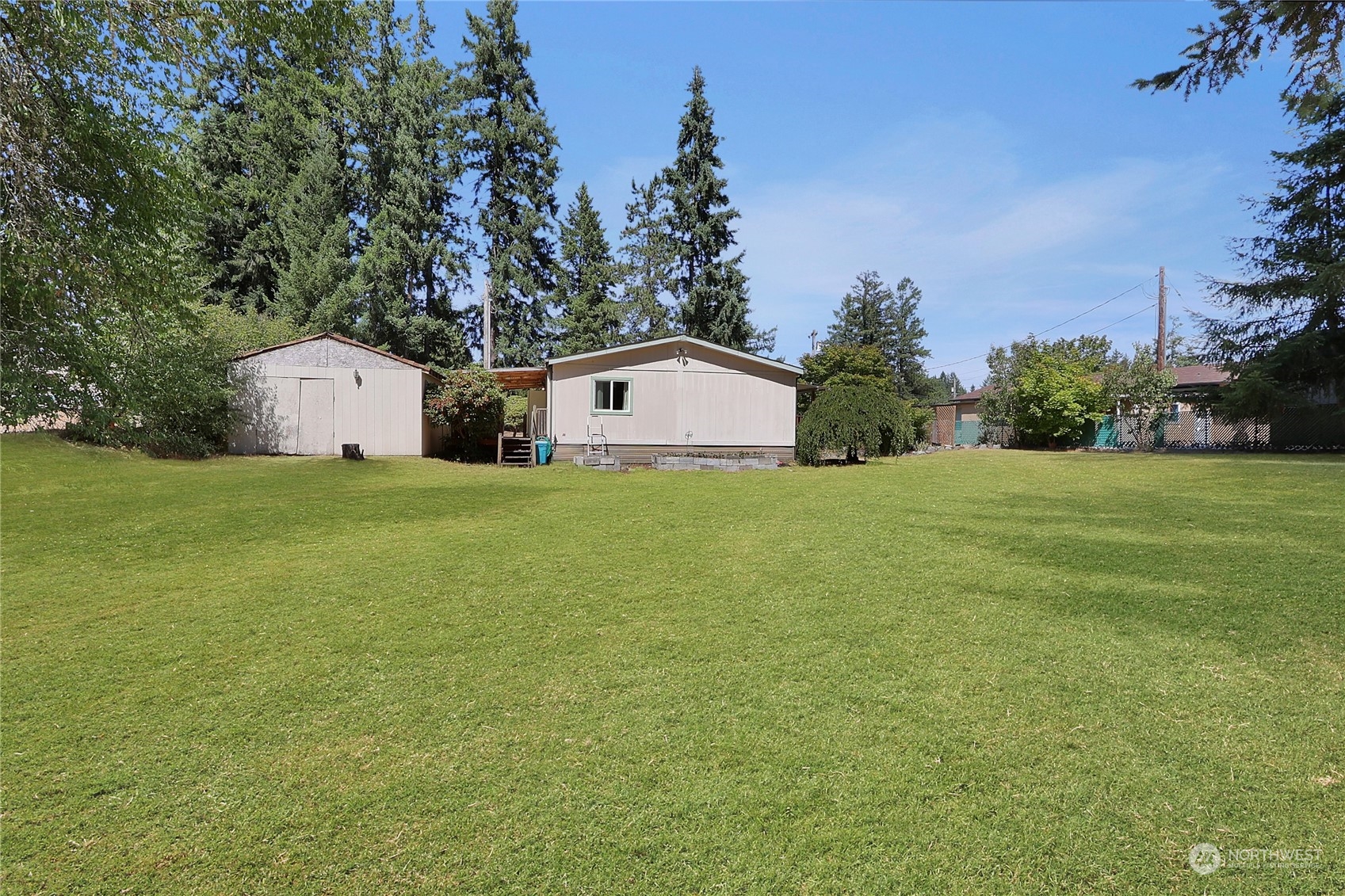 5334 254th Street East Graham, WA 98338 - Photo 22 of 33 a white house with a big yard and large trees