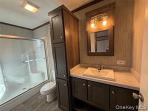 2898 Rte 9W New Windsor, NY 12553 - Photo 8 of 14 Bathroom with a shower with shower door, vanity, wood finished floors, and crown molding