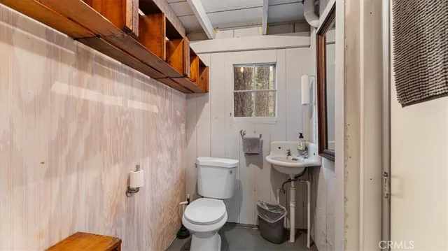 a bathroom with a toilet sink and shower curtain