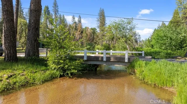 a view of swimming pool with a bench and trees