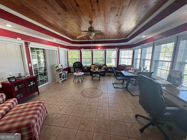 a living room with furniture a flat screen tv and a floor to ceiling window