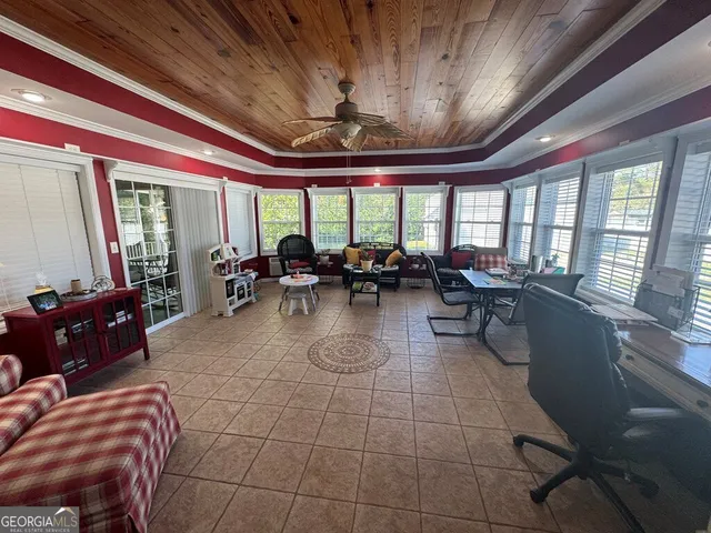 a living room with furniture a flat screen tv and a floor to ceiling window