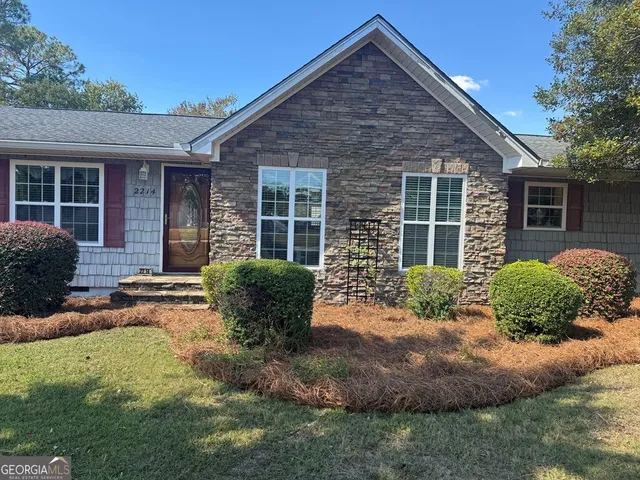 a kitchen with stainless steel appliances granite countertop a sink dishwasher stove and microwave with wooden floor