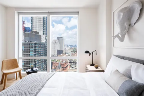 a bedroom with a large bed and a large window with outer view