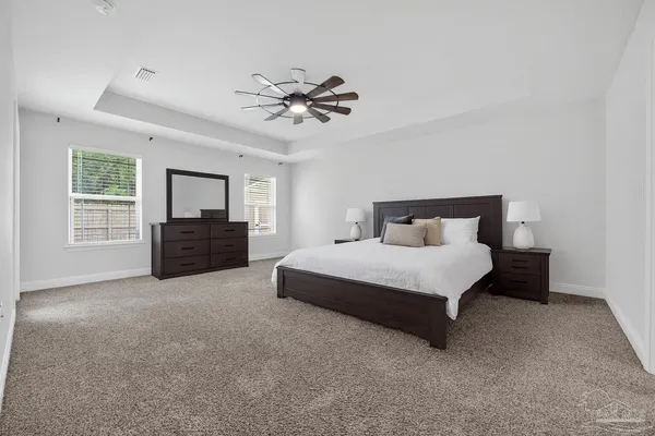 a spacious bedroom with a bed and a chandelier