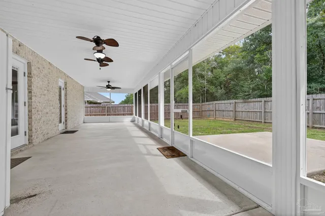 a view of a room with a ceiling fan and window