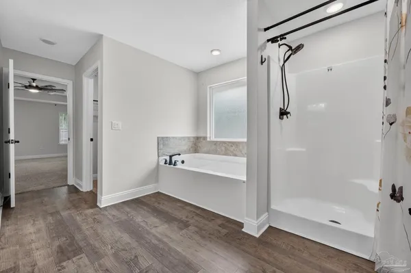 a bathroom with a tub shower vanity and a sink