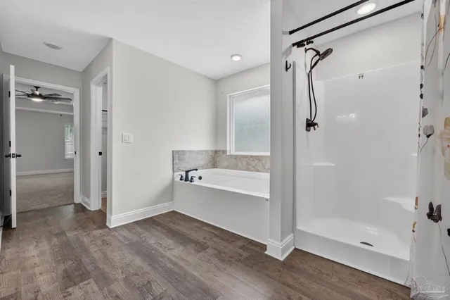 a bathroom with a tub shower vanity and a sink