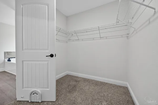 a view of walk in closet with empty racks
