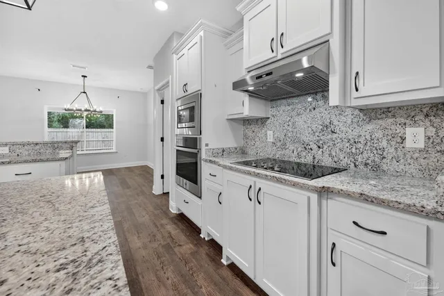 a kitchen with granite countertop a sink stainless steel appliances and cabinets