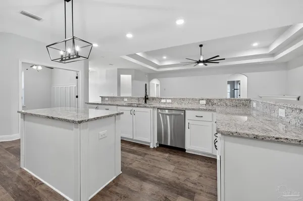 a kitchen with stainless steel appliances granite countertop a sink a stove a refrigerator and island