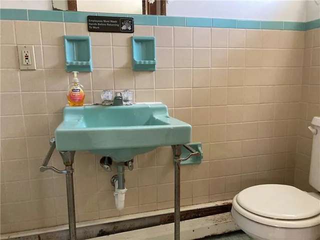 a bathroom with a sink toilet and mirror