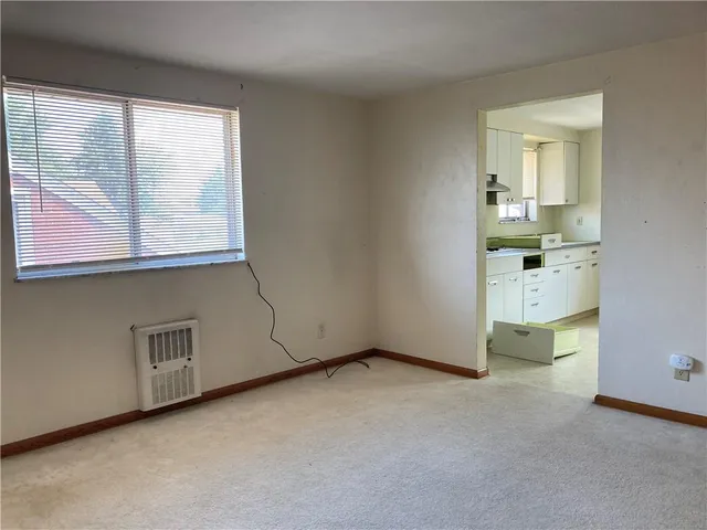 an empty room with a fireplace and window