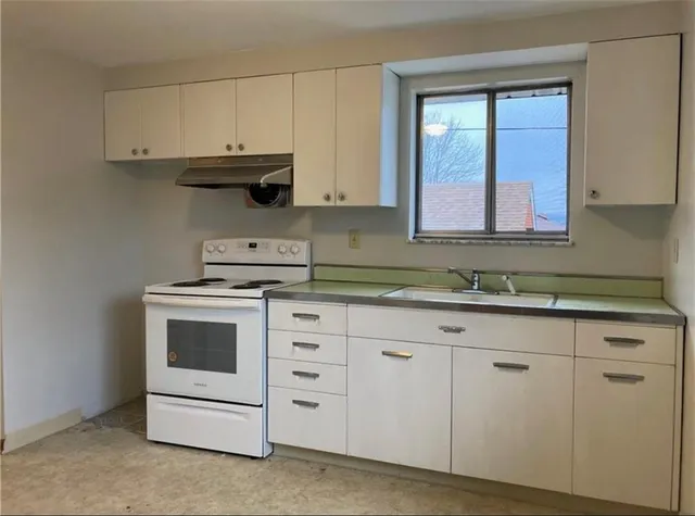 a kitchen with white cabinets and white appliances