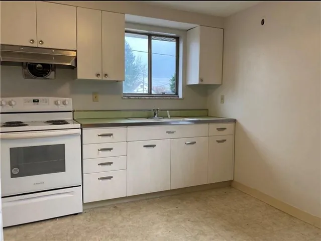 a kitchen with granite countertop white cabinets and white appliances