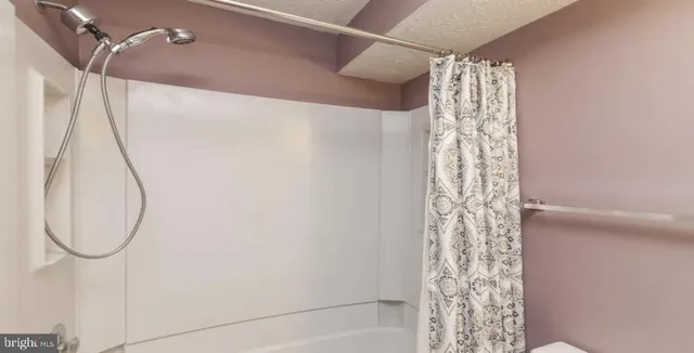 a bathroom with a shower curtain and a window