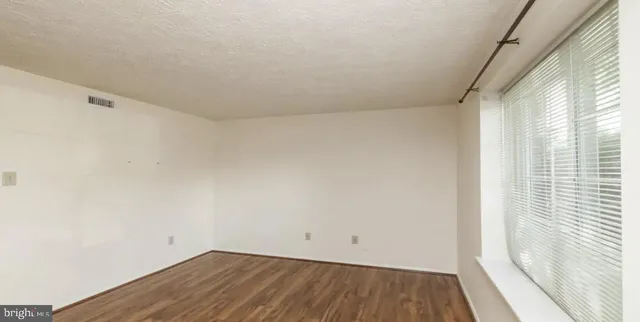 a view of a room with wooden floor and a window