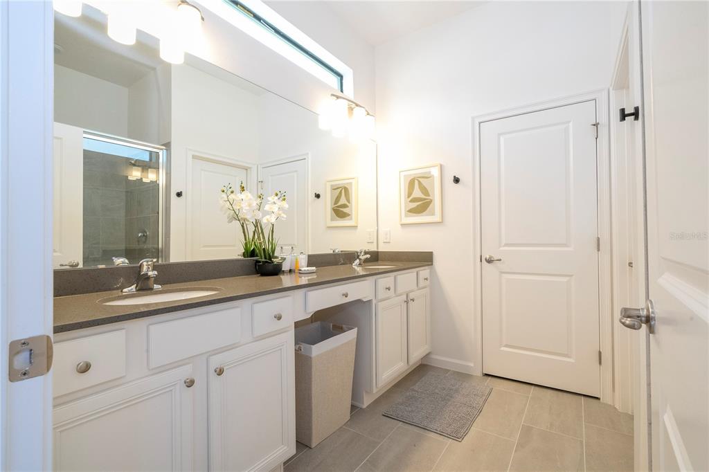 10018 Voyager Way Orlando, FL 32821 - Photo 12 of 100 a spacious bathroom with a double vanity sink a mirror and a