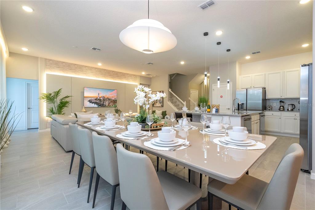 10018 Voyager Way Orlando, FL 32821 - Photo 30 of 100 a dining room with stainless steel appliances kitchen island a table and chairs
