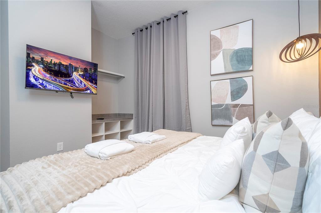 10018 Voyager Way Orlando, FL 32821 - Photo 42 of 100 a bedroom with a bed and a painting on the wall