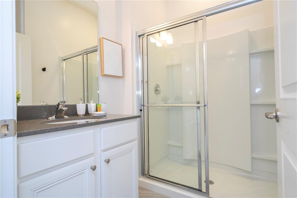 10018 Voyager Way Orlando, FL 32821 - Photo 43 of 100 a bathroom with a shower sink and mirror