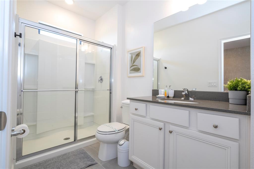 10018 Voyager Way Orlando, FL 32821 - Photo 58 of 100 a bathroom with a granite countertop sink mirror toilet and shower