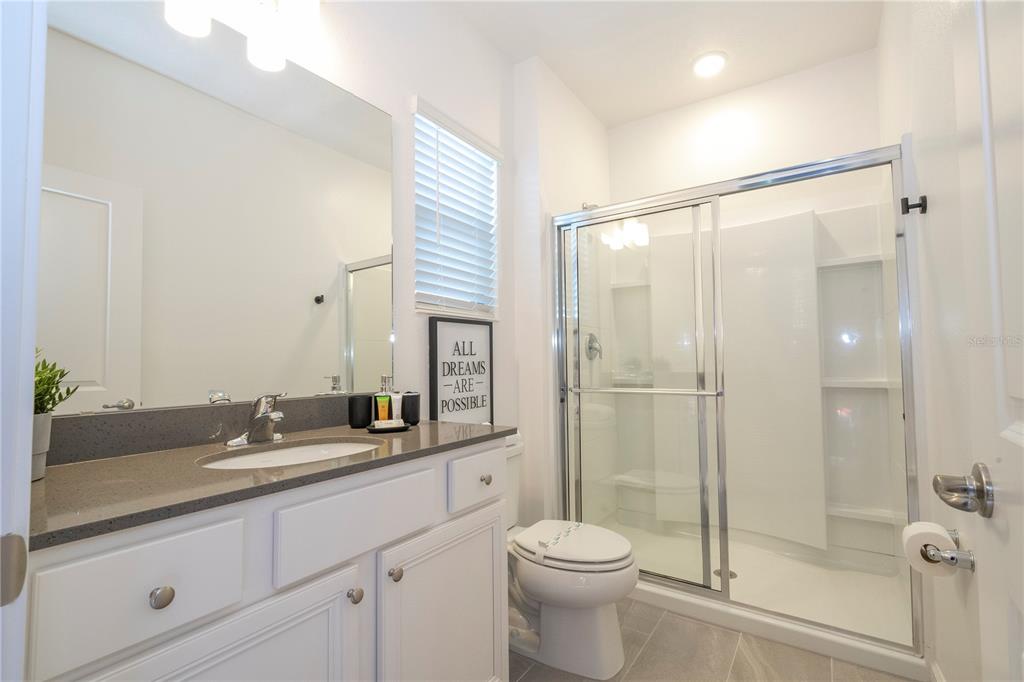 10018 Voyager Way Orlando, FL 32821 - Photo 63 of 100 a bathroom with a double vanity sink toilet and shower