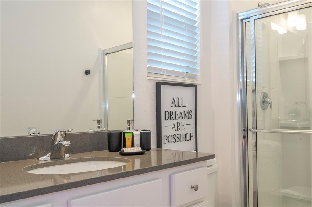 10018 Voyager Way Orlando, FL 32821 - Photo 64 of 100 a bathroom with a sink and a mirror