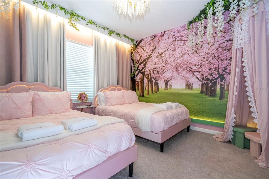 10018 Voyager Way Orlando, FL 32821 - Photo 71 of 100 a spacious bedroom with two beds and a chandelier