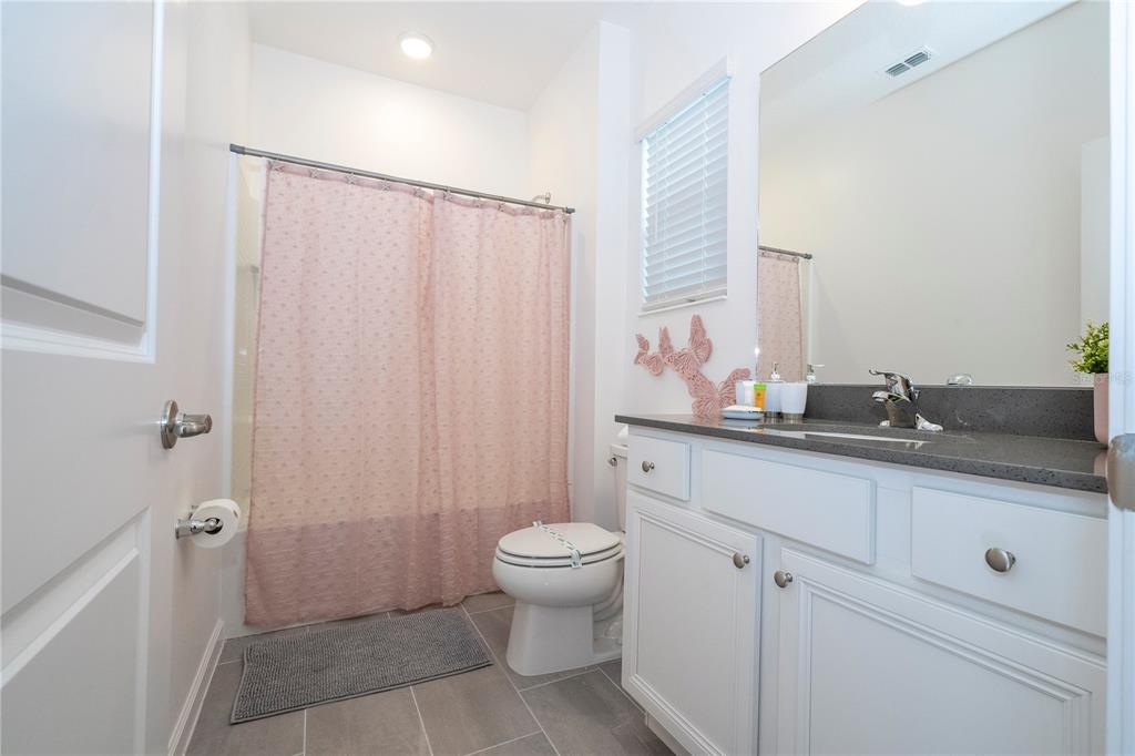 10018 Voyager Way Orlando, FL 32821 - Photo 73 of 100 a bathroom with a granite countertop sink a toilet and a mirror