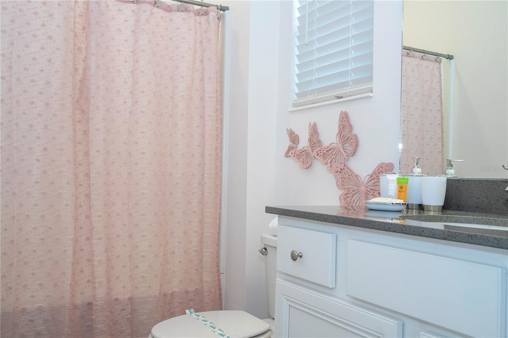 10018 Voyager Way Orlando, FL 32821 - Photo 74 of 100 a bathroom with a sink a toilet and a mirror