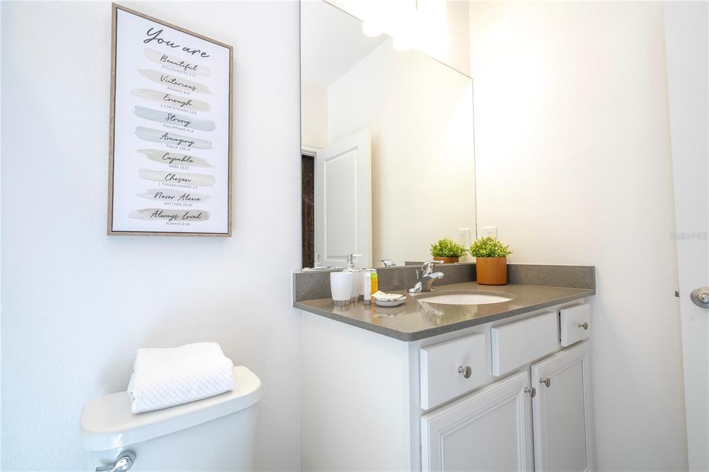 10018 Voyager Way Orlando, FL 32821 - Photo 85 of 100 a bathroom with a granite countertop sink a toilet and mirror