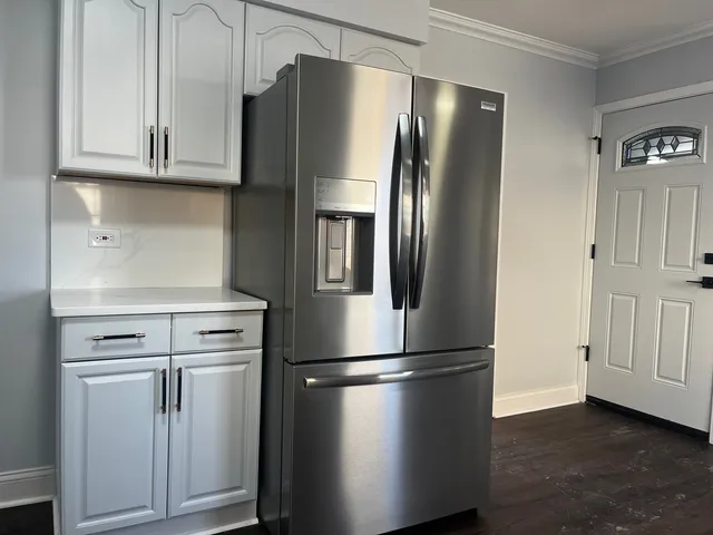 a metallic refrigerator freezer sitting in a kitchen