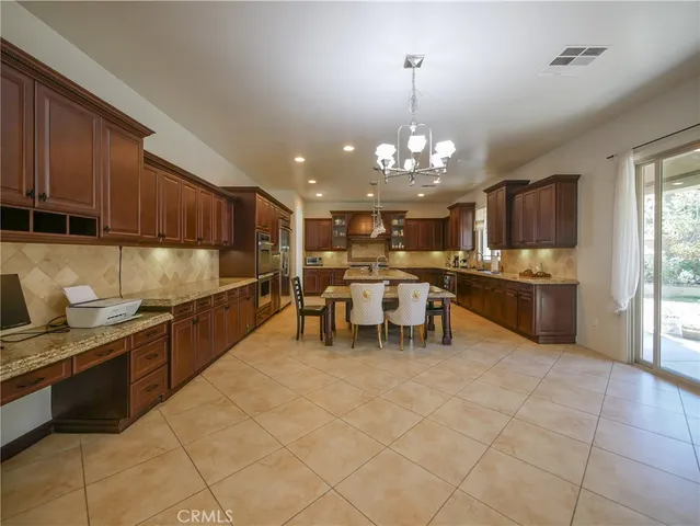 a kitchen with kitchen island granite countertop a sink stove and cabinets
