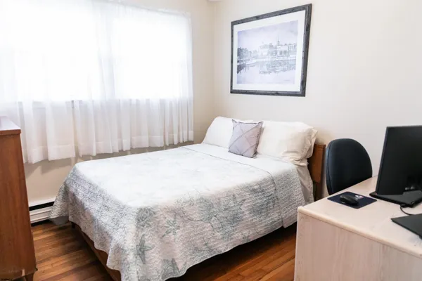 a bedroom with a bed and a wall painting