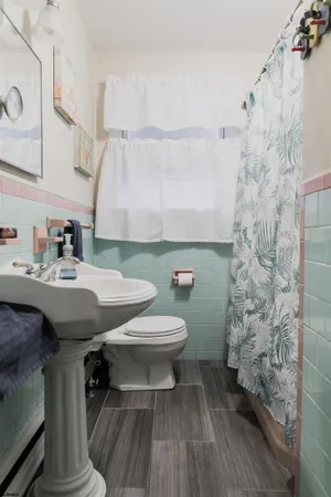 a bathroom with a sink and mirror with toilet