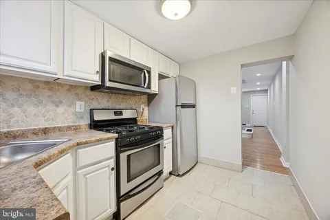 a kitchen with stainless steel appliances granite countertop a stove and a microwave