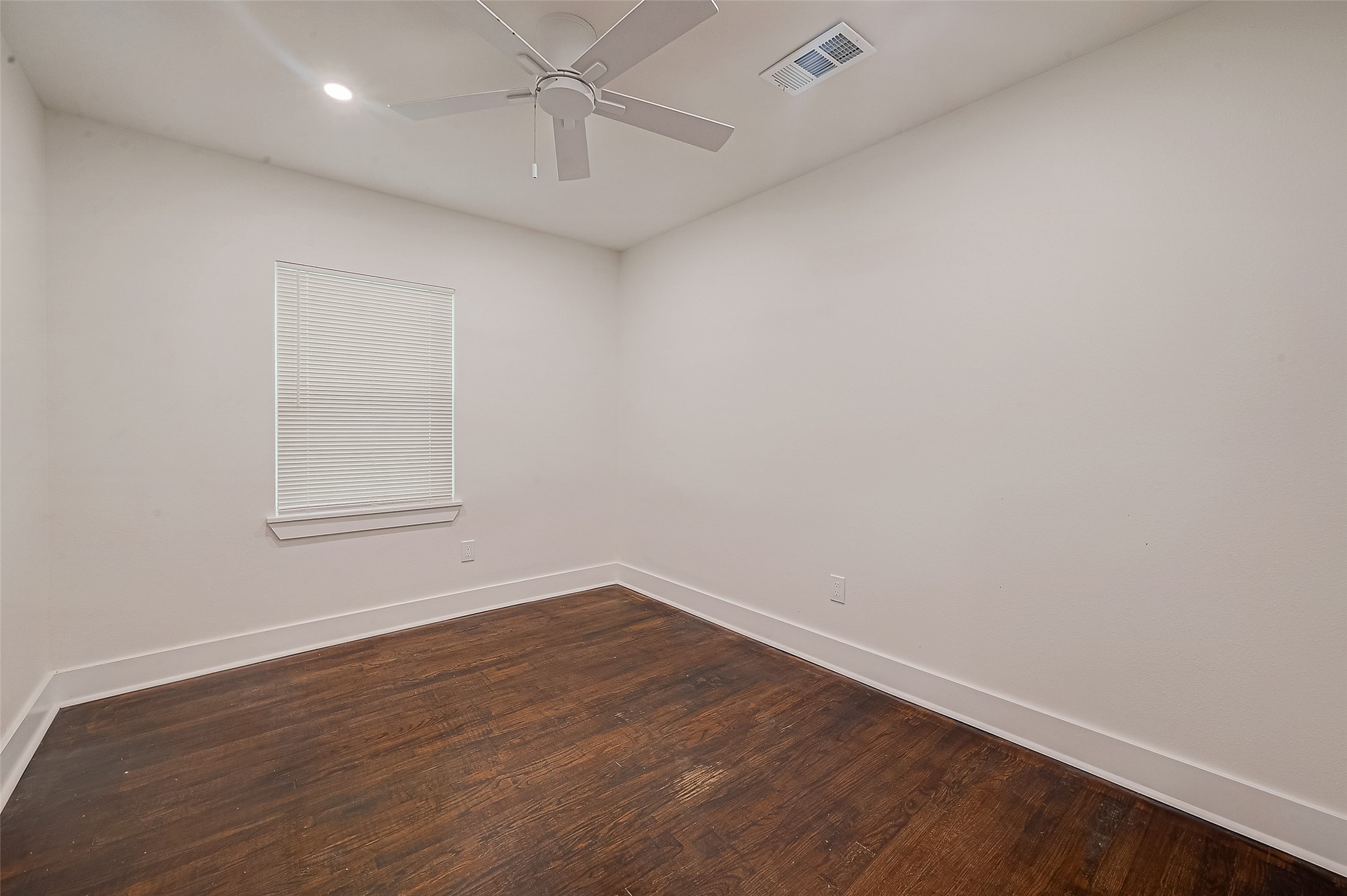 5703 Belmark Street Houston, TX 77033 - Photo 11 of 43 an empty room with wooden floor and windows