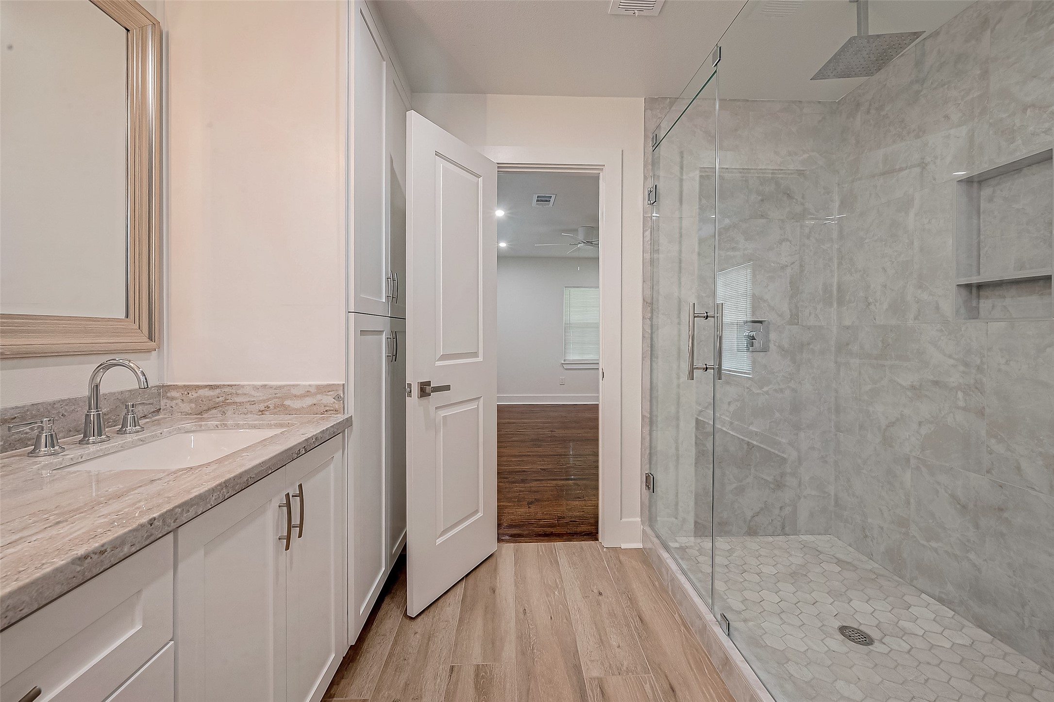 5703 Belmark Street Houston, TX 77033 - Photo 18 of 43 a bathroom with a granite countertop sink mirror and shower