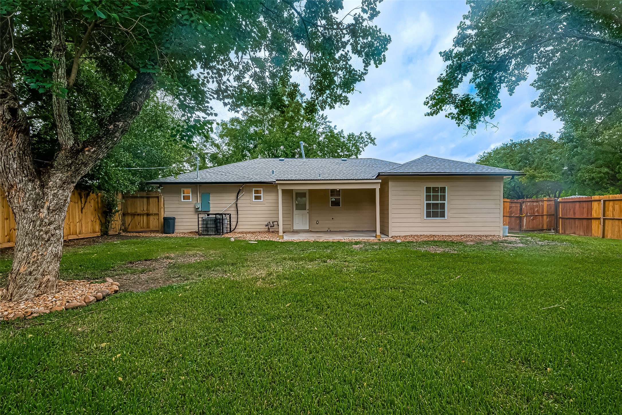 5703 Belmark Street Houston, TX 77033 - Photo 26 of 43 a view of a yard in front of a house with large trees