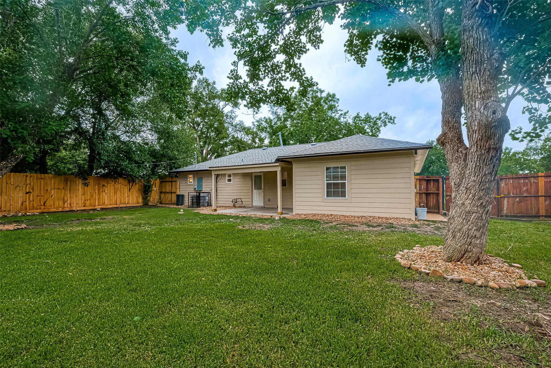 5703 Belmark Street Houston, TX 77033 - Photo 27 of 43 a view of a backyard with plants and a large tree