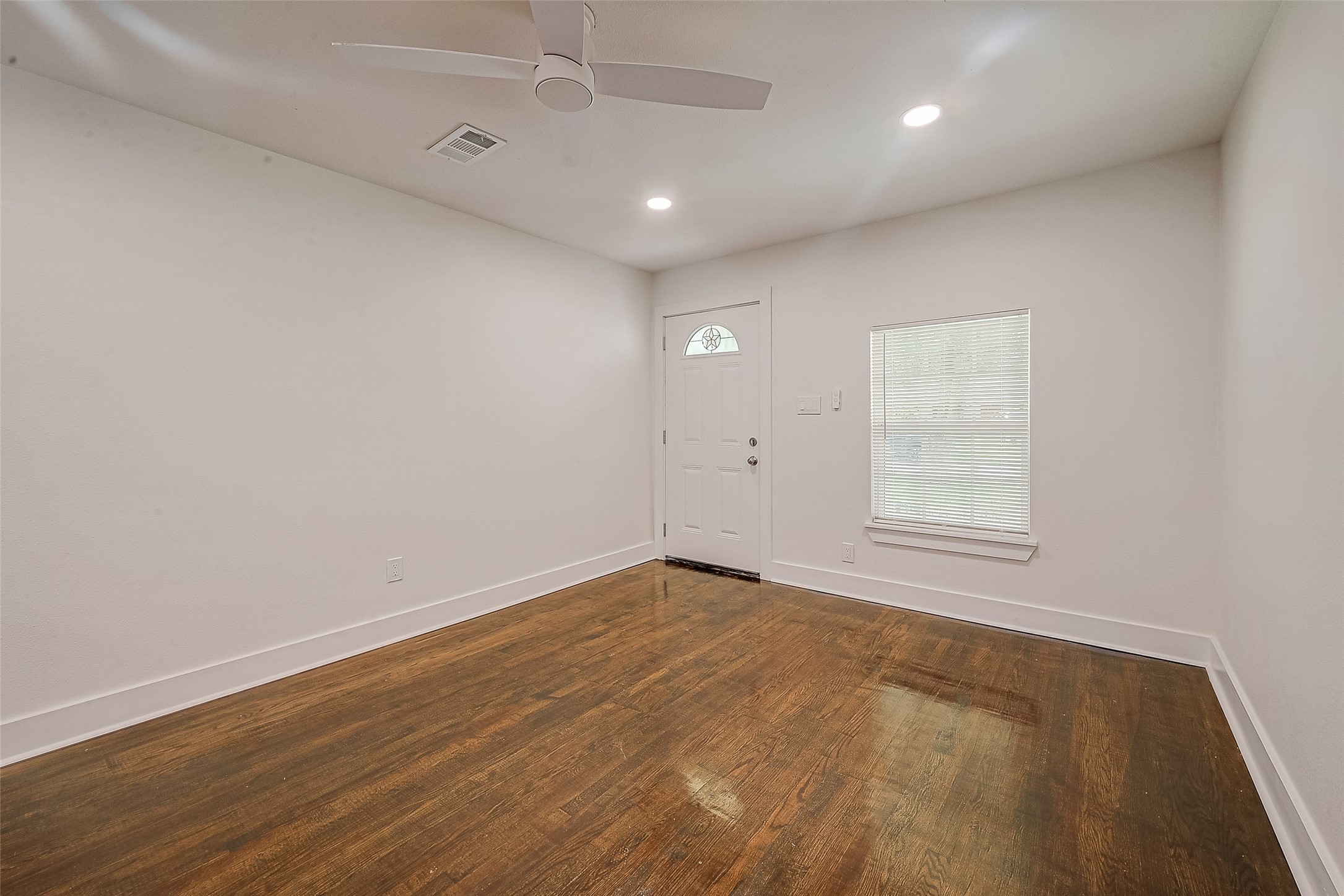5703 Belmark Street Houston, TX 77033 - Photo 32 of 43 an empty room with wooden floor and windows