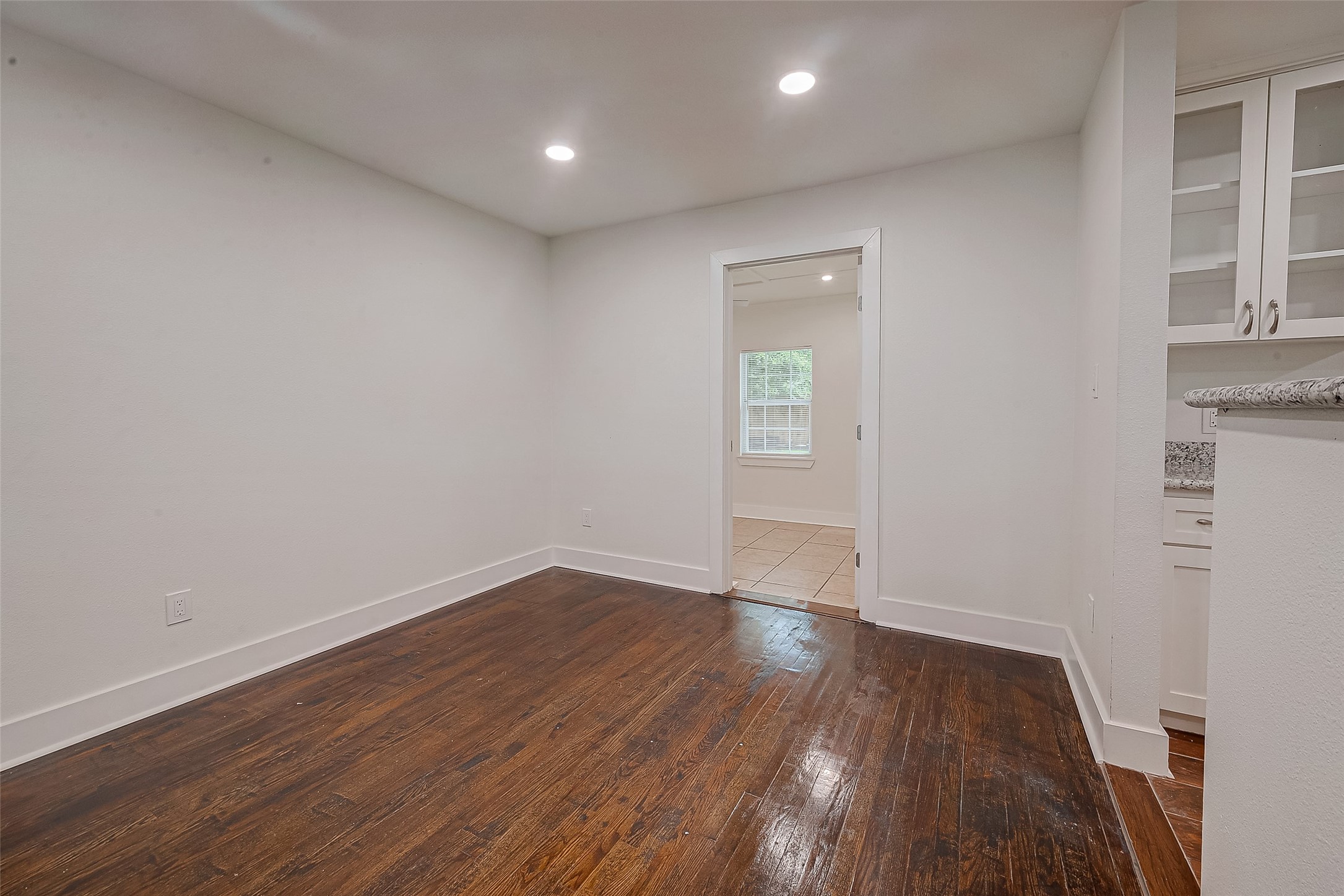 5703 Belmark Street Houston, TX 77033 - Photo 8 of 43 an empty room with wooden floor and windows