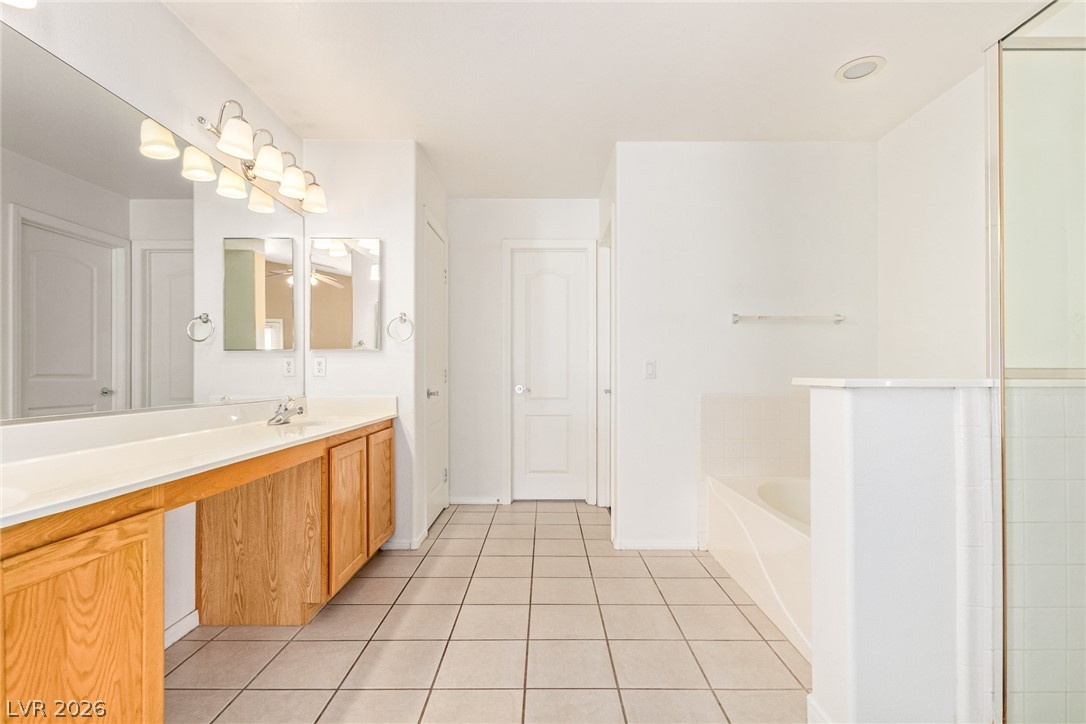 1477 Rancho Ridge Drive Henderson, NV 89012 - Photo 20 of 46 A well-lit bathroom provides a dual vanity and a combination of tub and shower for ultimate convenience.