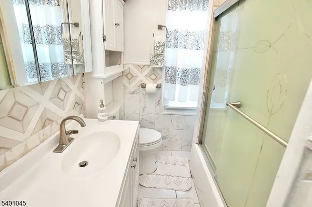 a bathroom with a sink a toilet and a large mirror