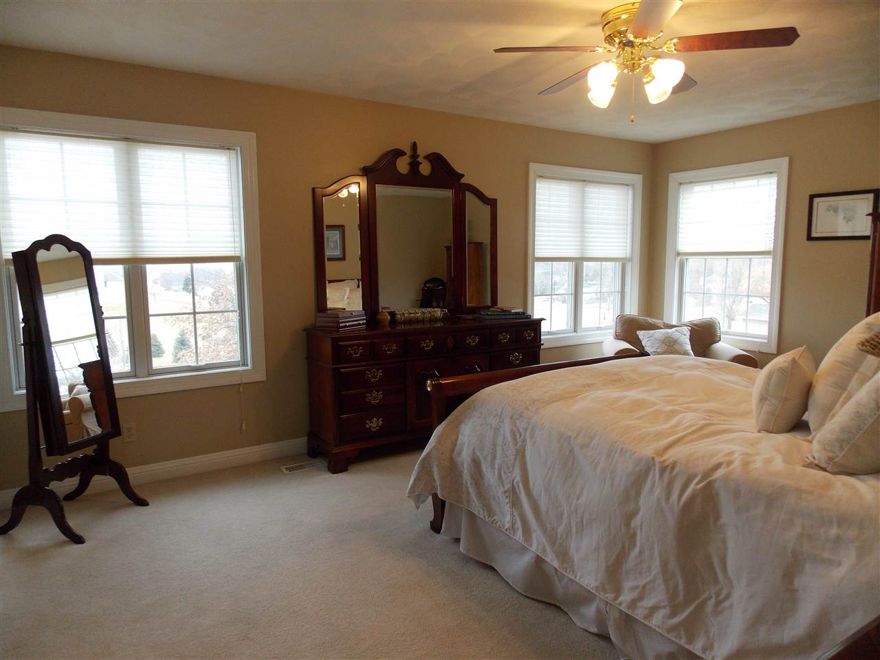 4373 Ridgeview Lane Byron, IL 61010 - Photo 14 of 22 a spacious bedroom with a bed a chandelier and a flat tv screen on dresser