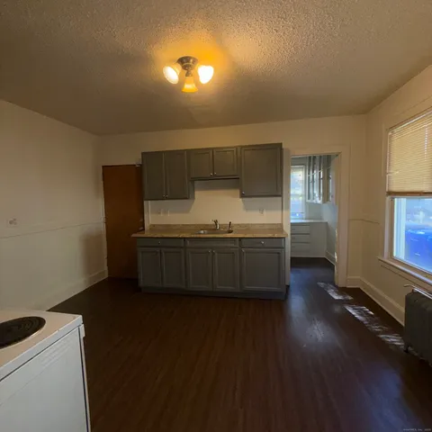 a kitchen with stainless steel appliances a sink cabinets and wooden floor