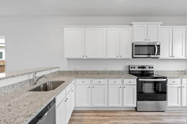 a kitchen with a sink stove and microwave